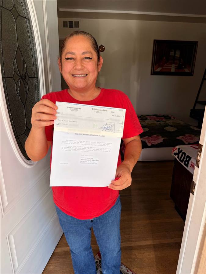 Ana at her front door holding her case documents